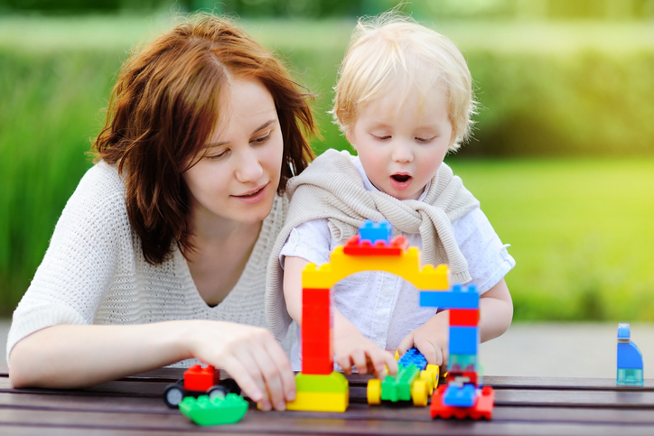 Young_woman_and_toddler_playing_with_blocks